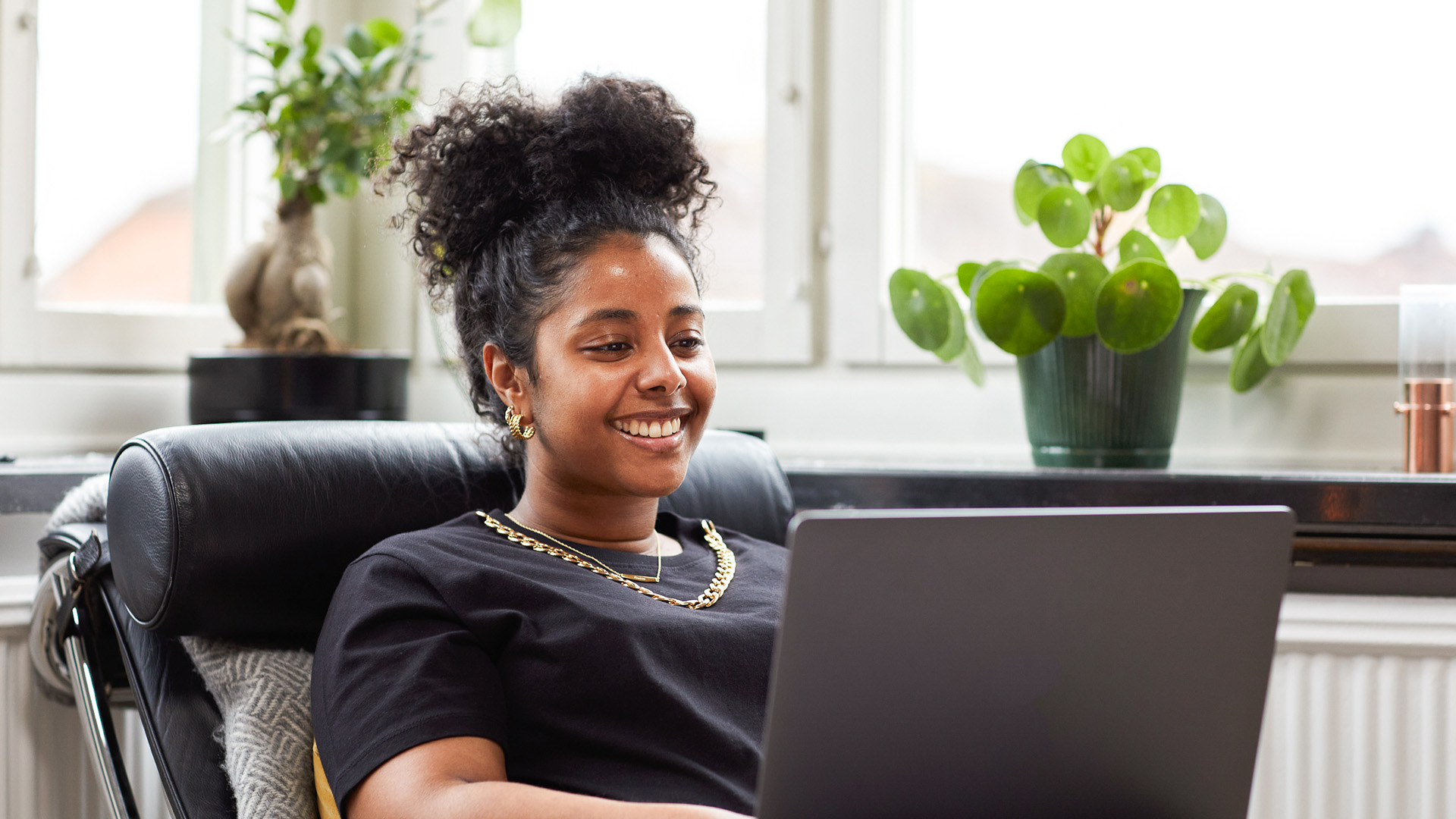 Leende kvinna med laptop i knät