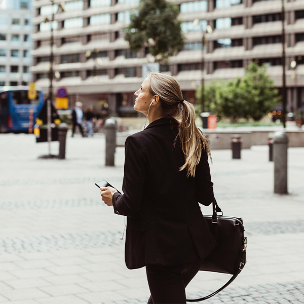 Kvinna går över ett torg och pratar i mobiltelefon