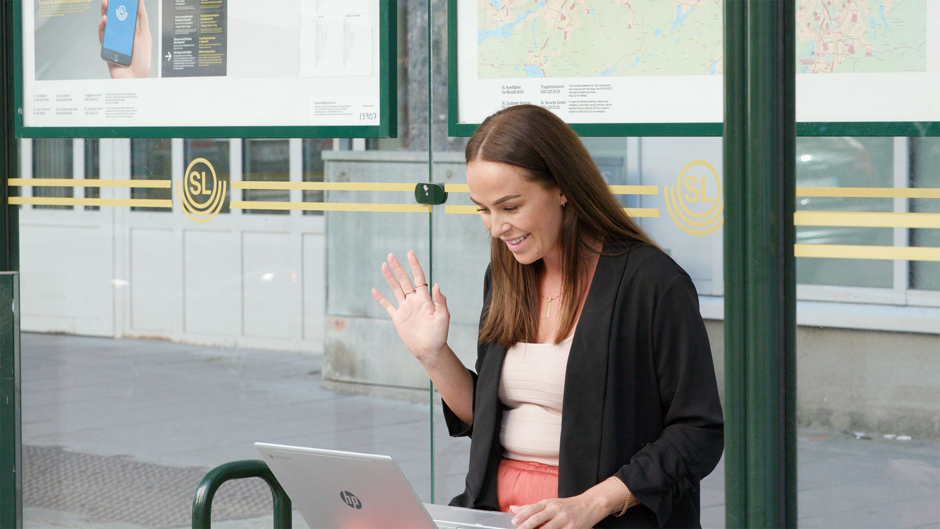 Kvinna sitter på busshållsplats och jobbar effektivt med Microsoft Teams