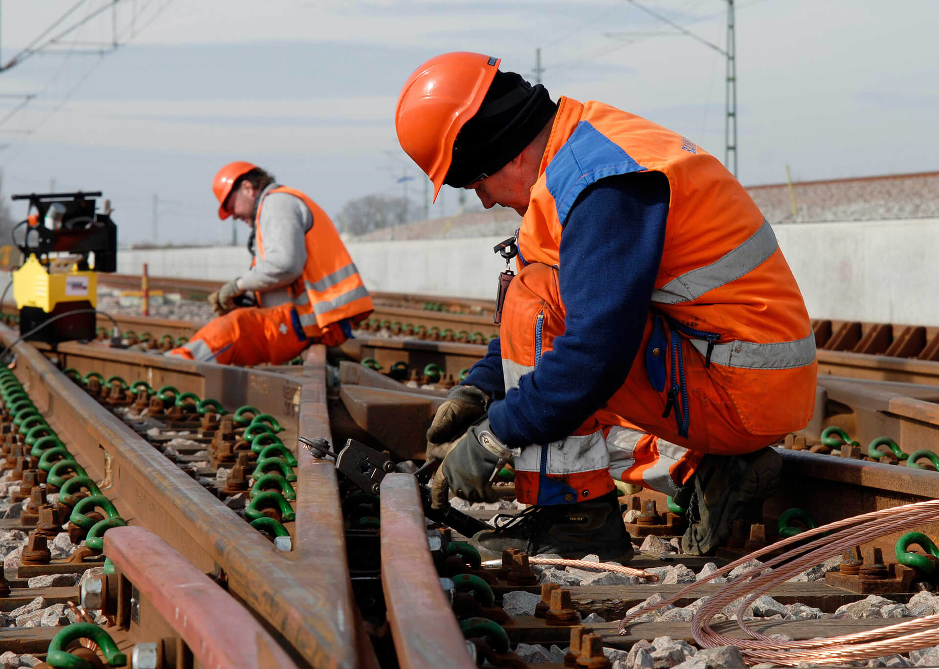 Personer bygger järnspår och ser till att tågen går