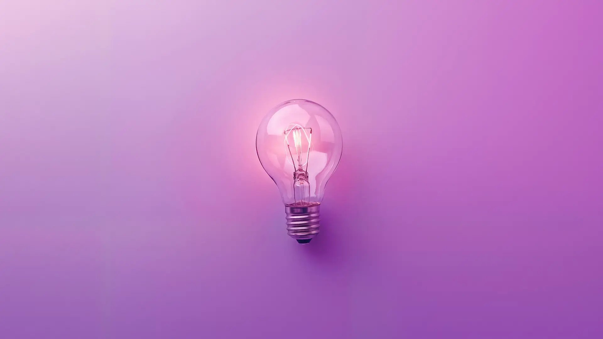Lysande glödlampa på lila bakgrund