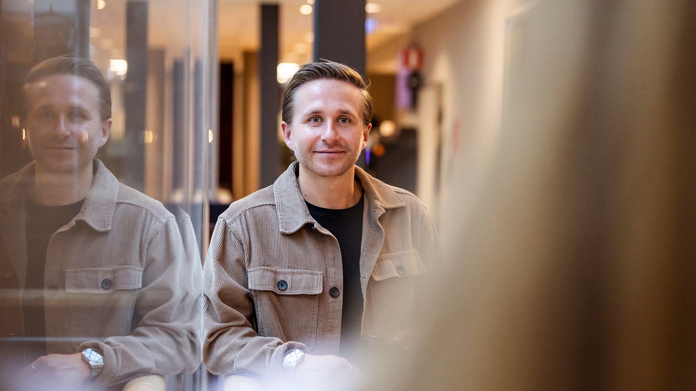 Manlig kollega som arbetar i kontorsmiljö och ler mot kameran