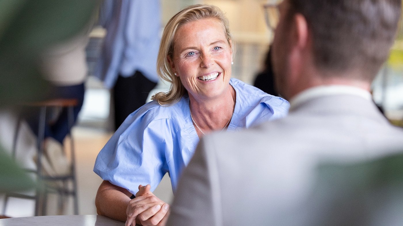 Kvinnlig medarbetare som sitter och pratar med en kund