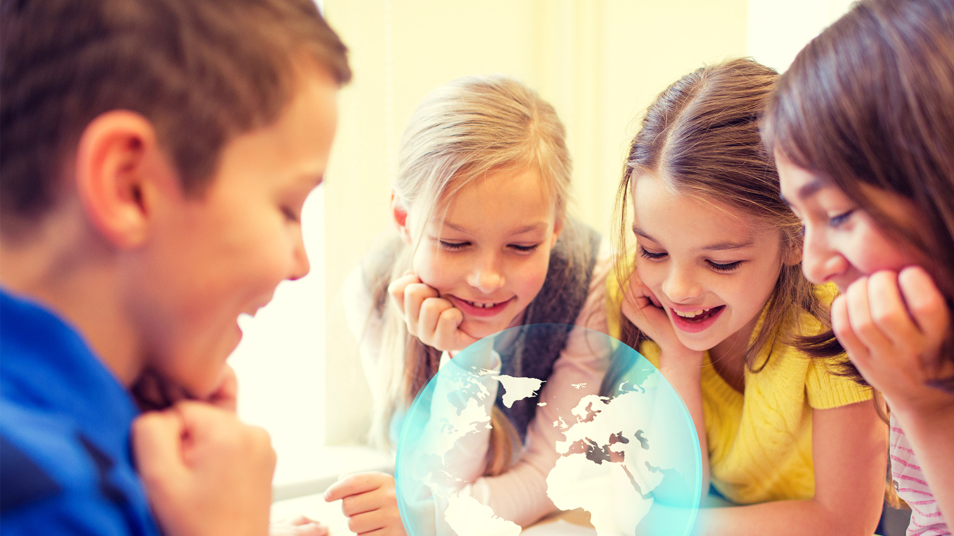 Fyra barn sitter tillsammans och tittar nyfiket på en digital jordglob som svävar framför dem. De ser glada och engagerade ut.