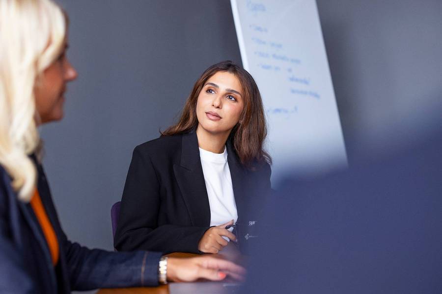business, women, meeting, whiteboard, boardroom, suit, black blazer, white shirt, blonde hair, brunette hair